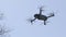 Black drone, quadrocopter in the blue sky