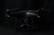 black drone and silver camera on black background