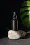 Black dropper bottle with organic essential oil for hair on stone