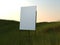 Black easel with canvas in a grassfield . 3d rendering