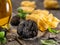 Black edible winter truffle, tagliatelle and fresh basil on wooden table. The most popular cooking ingredients