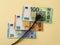 Black electric plug over 20, 50 and 100 euro banknotes. Concept of rise in electricity prices