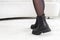 Black elegant shoes on women& x27;s legs. Leather winter boots, stylish lady footwear concept