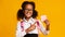 Black Elementary Student Girl Pointing At Blank Paper, Yellow Background