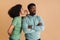 Black excited woman whispering secret at man\\\'s ear