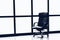 Black executive leather chair in empty office space with large window