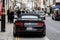 A black, expensive sports muscle car parked on the edge of a city street, London, England, UK