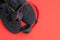 Black fabric sneakers and on-ear headphones on a red background.