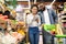 Black Family Buying Food Taking Notes In Checklist In Supermarket