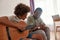 Black father show son how play on acoustic guitar