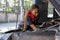 A black female automotive mechanical worker checks EV car at a fixing garage.