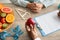 Black female doctor dietologist giving apple to woman patient during session, nutritionist writing dieting plan