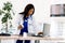 Black female doctor stands at an office desk looking to laptop, african american nurse work on laptop in cabinet, modern