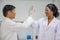 Black female and professor scientist in protective glasses and gloves Clap and congratulate in laboratory,test sample antibiotics