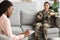 Black Female Psychotherapist Taking Notes During Therapy Session With Military Woman