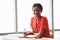 Black female writer looking into camera while wearing bright blouse