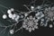 Black festive Christmas background with contrasting white objects - natural painted white branch, snowflakes, Christmas toys,