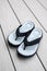 Black Flip Flops on Gray Deck Background