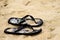 Black Flip Flops in Sand