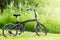 Black folding bicycle in grass