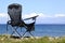 Black folding tourist chair on the background of the Japanese sea without people. with copy space