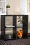 Black four cube organizer with houseplants and oranges in a metal basket - concept of house interior