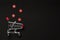 Black Friday sale concept. Shopping cart and red stars on dark background. Holiday shopping for Christmas, Saint Valentine`s day