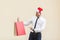 Black friday in winter. Happiness red head businessman in santa hat , holding shopping bags on hands, pointing fingers and looking