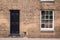 Black front door on a restored brick wall of a Victorian house r