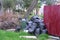 Black garbage bags near the fence of private house and an overturned trash can.