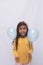 Black girl in yellow shirt playing, photo with white background. child playing with balloon isolated