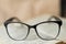 Black glasses lie on an open book, reading, sight, leisure, hobby