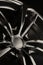 Black Gloss alloy wheel on a dark background. Stylish and expensive. Close-up of spoke elements, vertical photo,