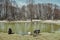 a black goat with a small white goat drinks water from a small lake