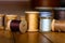 Black, Gold, White, Beige, Silver, Yellow, and Dark Grey Wooden Spools of Thread Sit on a Surface of Wooden Planks