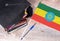 Black graduation hat on books next to Ethiopia flag, education concept