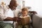 Black Grandfather And Grandson Reading A Book Together At Home