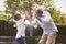 Black grandfather playing with his grandson in a garden