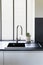 Black granite kitchen sink in a modern style, steel chrome water tap in the kitchen with single bowl sink