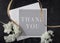 Black gray and white thank you note flat lay with white blossoms