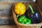 Black, green and yellow paprika`s in a basket.