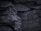 Black grunge background. Rock texture. Fragment of a mountain close-up. Stone background. Dark gray rock texture for grunge backgr