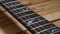Black guitar neck close-up on a wooden background