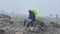 A black guy with a large backpack sits on a large stone. Foggy mountain landscape. Climbing Kilimanjaro, Africa