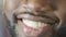 Black guy smiling to camera with charming smile, white teeth, super close-up