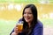 black hair latin woman drinking beer outdoors taking selfie with view of san miguel de allende parish in guanajoato mexico