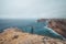 Black-haired adventurer stands at the end of Cape Cabo de Sao Vicente in the southwest of Portugal in the Algarve region. Man is