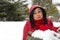 Black haired Turkish upset women looking at red heart on snow and celebrating Valentine\'s day alone