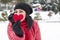 Black haired Turkish women holding a red heart with black warm wool gloves and celebrating Valentine\'s day