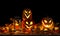 Black Halloween background with carved scary pumpkins